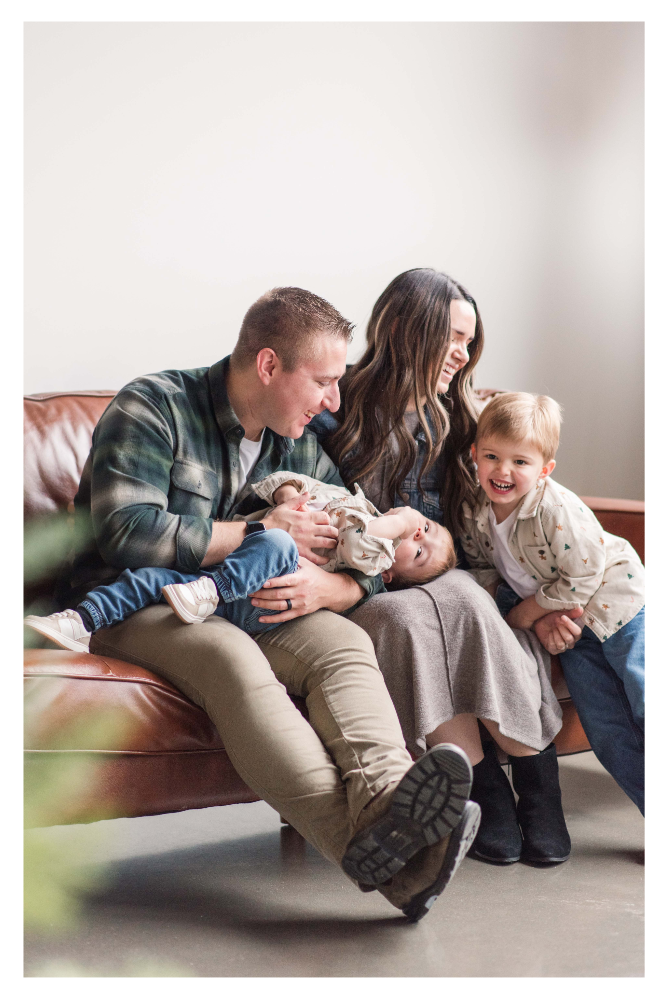 family of four snuggles on the couch during a family mini session